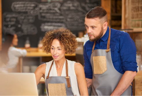retail using laptop man and woman workers cafe 600px-1