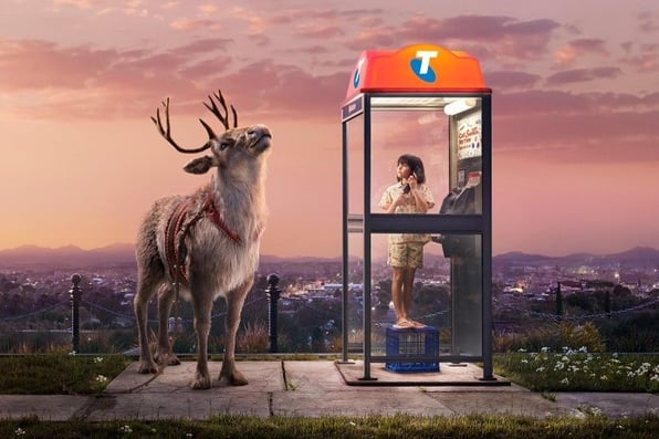 Raindeer with girl on phone in Telstra phone booth