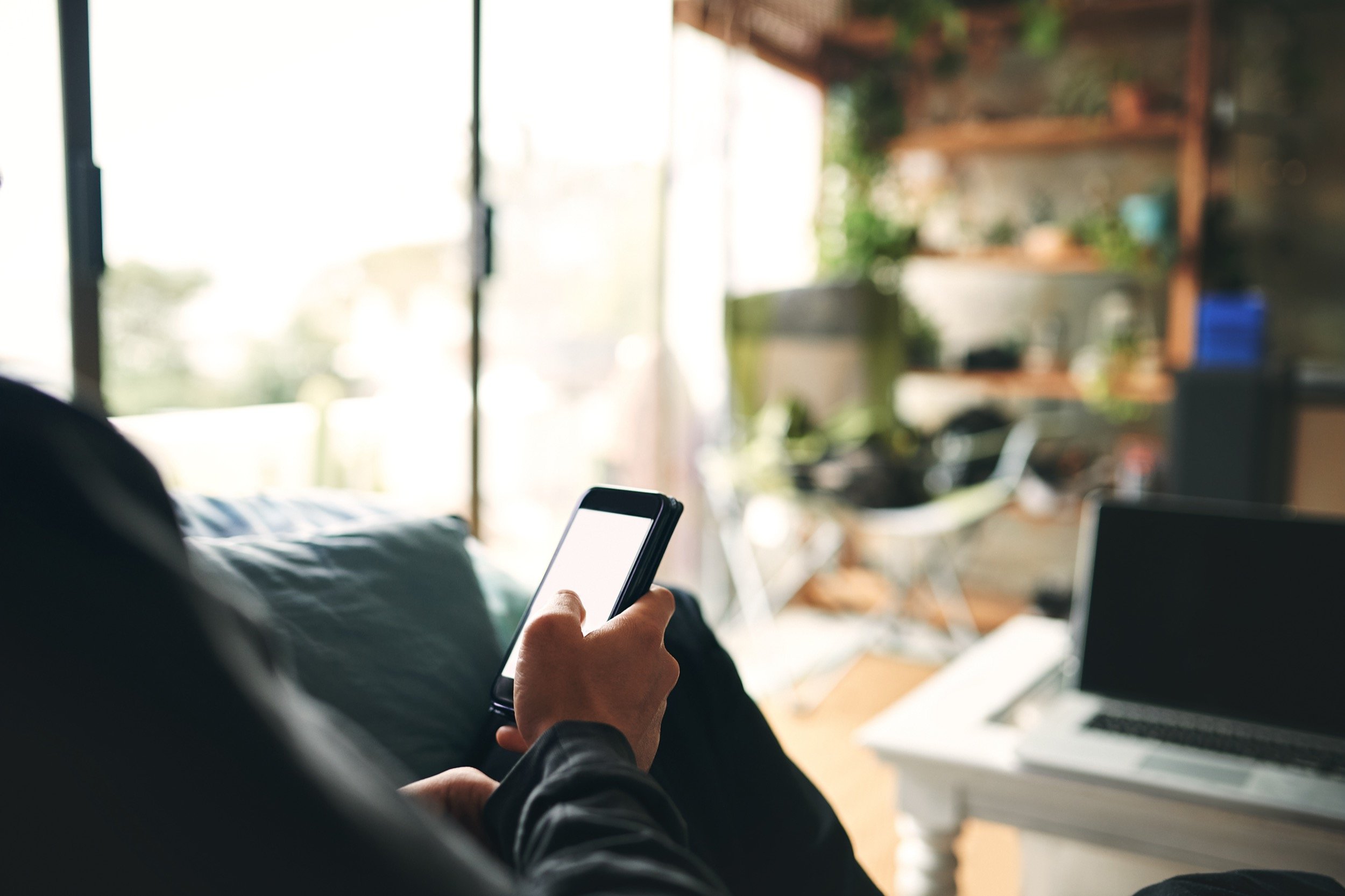 person-using-smart-phone-on-sofa-indoors-2026-03-25-02-19-39-utc